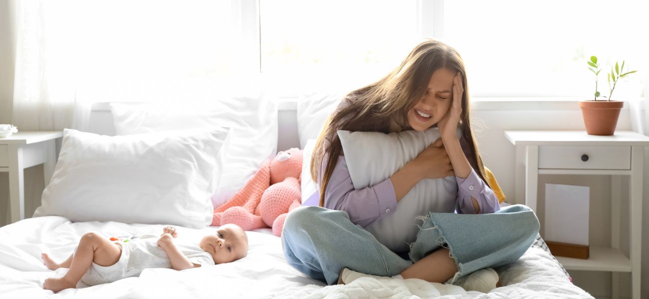 Overwhelmed new mother with baby experiencing postpartum anger